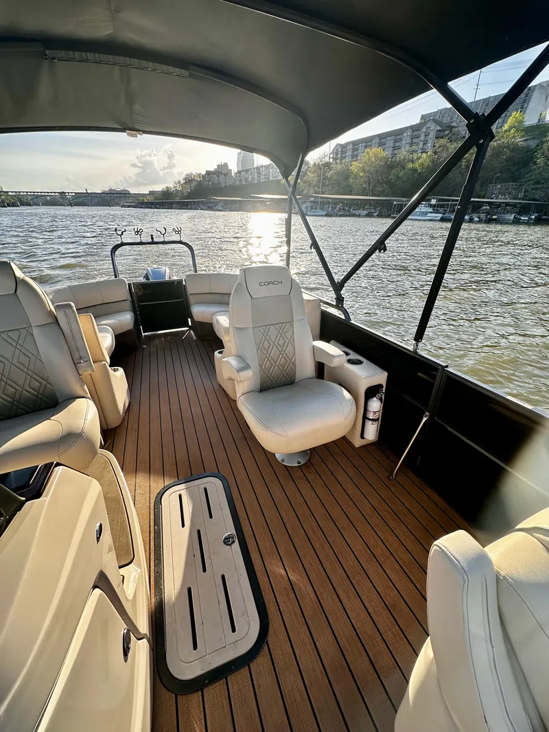 Slide: The Image of 2019 Coach Pontoons 230 RF on water, featuring spacious seating and elegant design. - 11