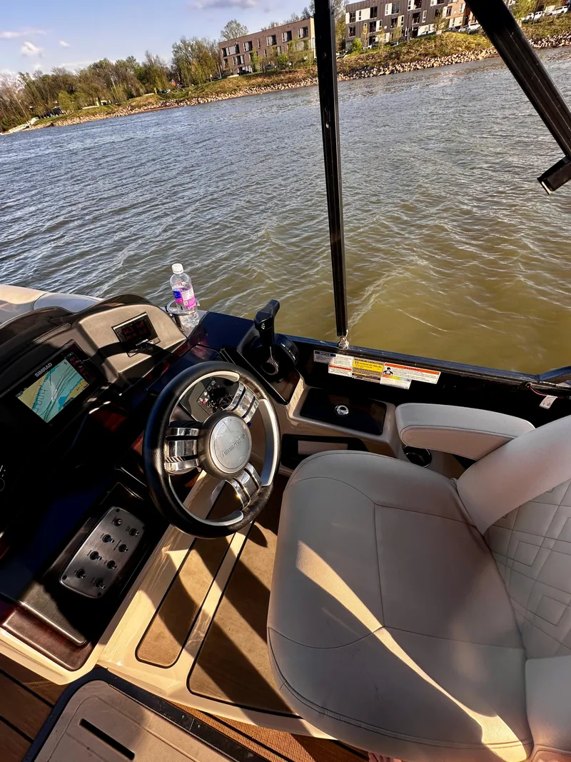 Slide: The Image of 2019 Coach Pontoons 230 RF interior with steering wheel and water view. - 14