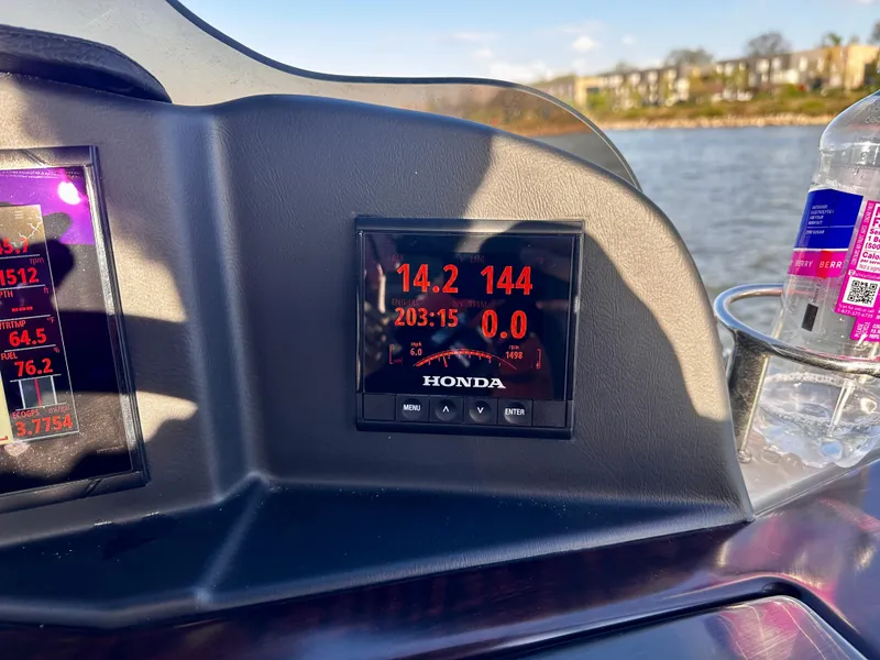 Slide: The Image of Dashboard of a 2019 Coach Pontoons 230 RF with Honda display, near water. - 15