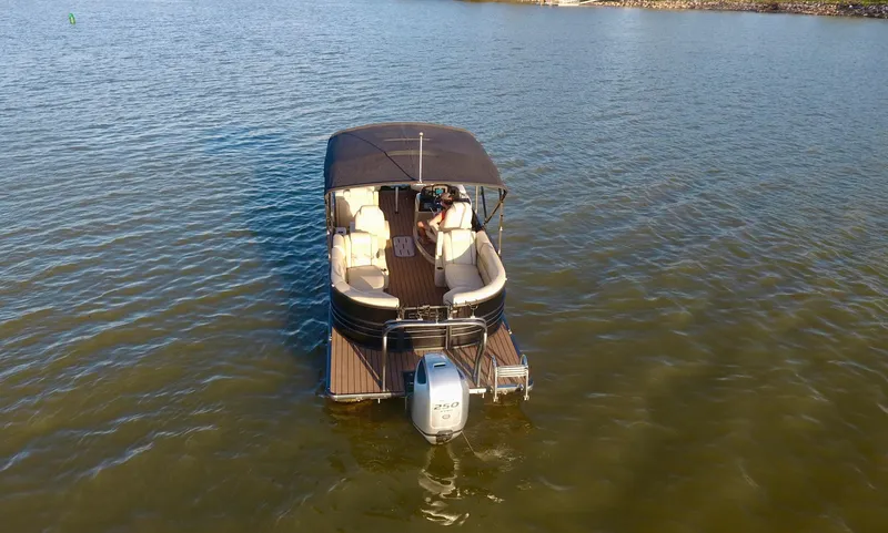 Slide: The Image of 2019 Coach Pontoons 230 RF on calm water, rear view with canopy and outboard motor. - 7