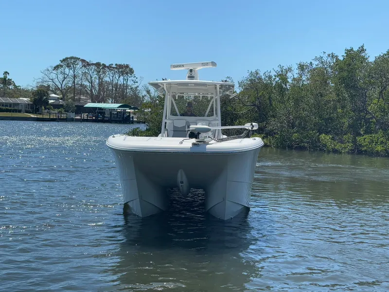 Slide: The Image of 2022 Invincible 33 Catamaran on calm water, front view, clear sky. - 2