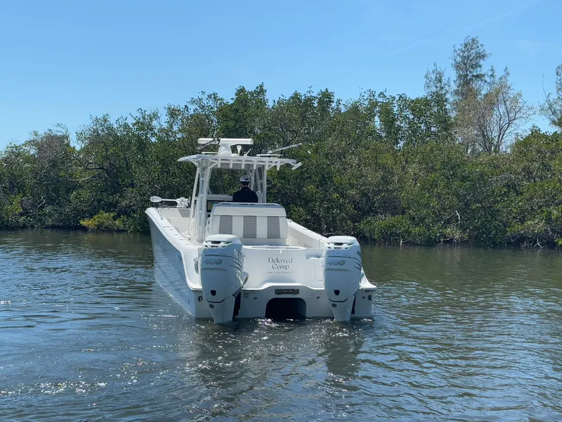 Slide: The Image of 2022 Invincible 33 Catamaran navigating through calm waters near lush greenery. - 6