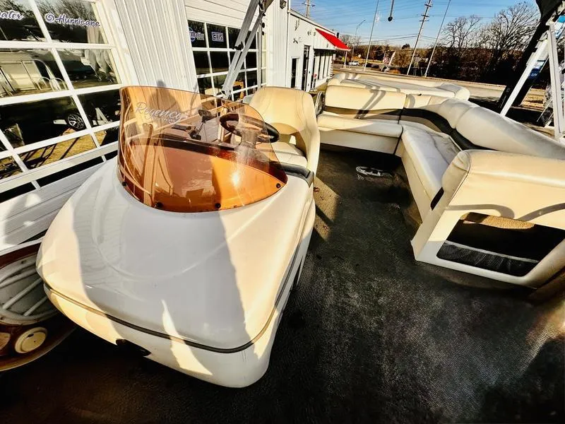 Slide: The Image of 2006 Sun Tracker PARTY BARGE interior with seating and helm, parked outdoors. - 14