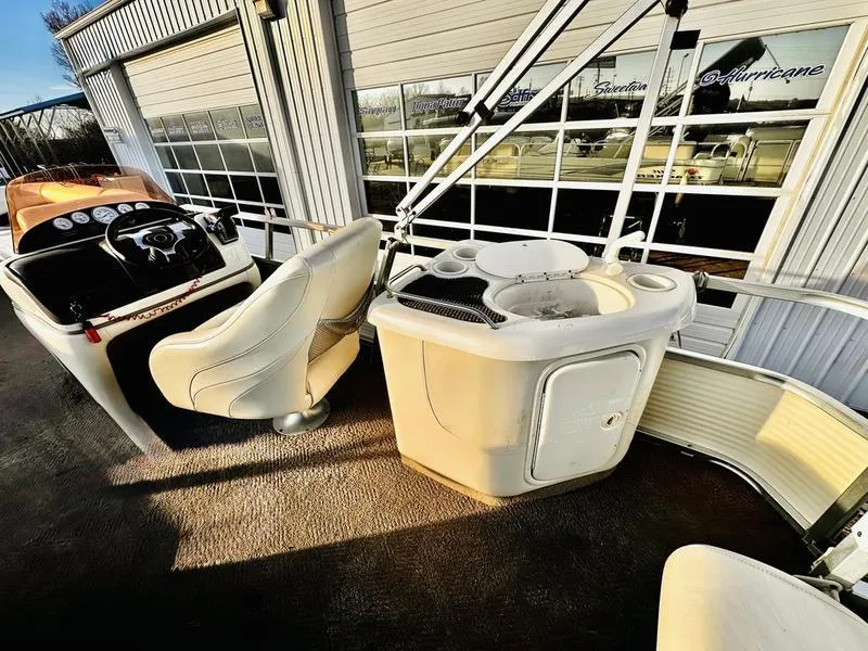 Slide: The Image of 2006 Sun Tracker PARTY BARGE interior with helm and seating area, docked near a building. - 16