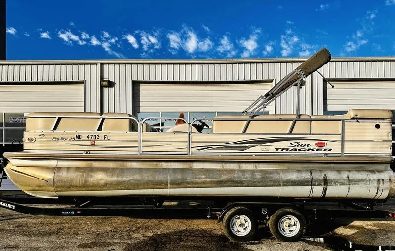 Slide: The Image of 2006 Sun Tracker PARTY BARGE pontoon boat on trailer, parked outside a building. - 20