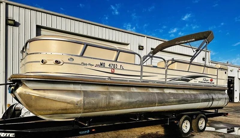 Slide: The Image of 2006 Sun Tracker PARTY BARGE pontoon boat on trailer, parked outside a warehouse. - 21