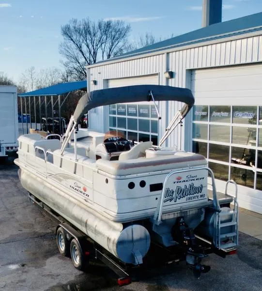 Slide: The Image of 2006 Sun Tracker PARTY BARGE pontoon boat on trailer, parked outside a garage. - 3