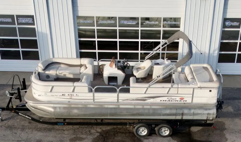 Slide: The Image of 2006 Sun Tracker PARTY BARGE pontoon boat on trailer, parked outside a garage. - 8