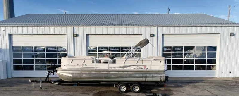 Slide: The Image of 2006 Sun Tracker PARTY BARGE pontoon boat on trailer, parked in front of a garage. - 9