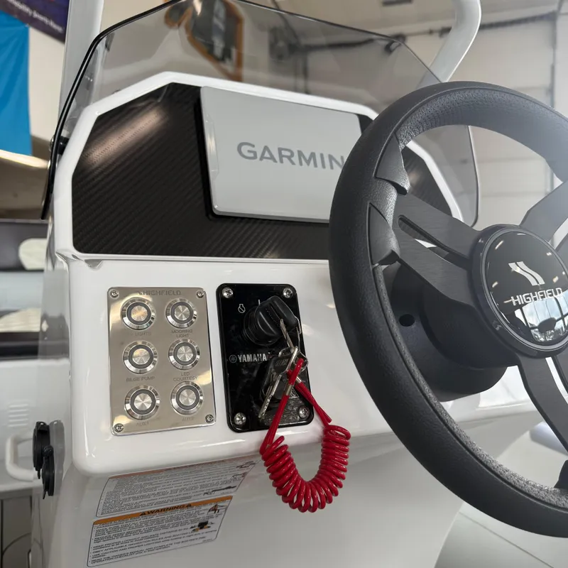Slide: The Image of Interior view of a 2025 Highfield Sport 390 boat, featuring control panel and seating area. - 14