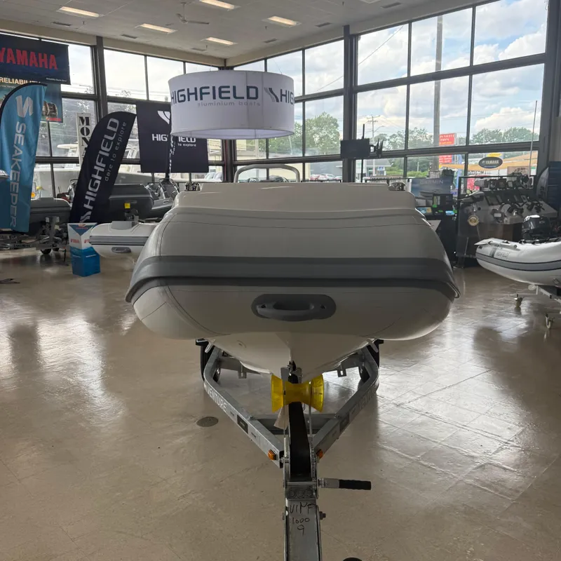 Slide: The Image of 2025 Highfield Sport 390 boat displayed indoors with large windows in the background. - 5