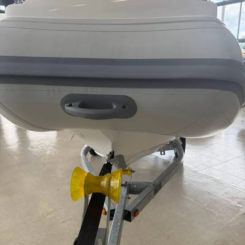 Slide: The Image of 2025 Highfield Sport 390 boat displayed indoors with promotional banners. - 6