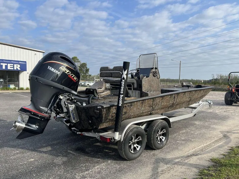 Slide: The Image of 2025 Xpress H210 BAY boat with Yamaha engine on a trailer, parked outdoors. - 12