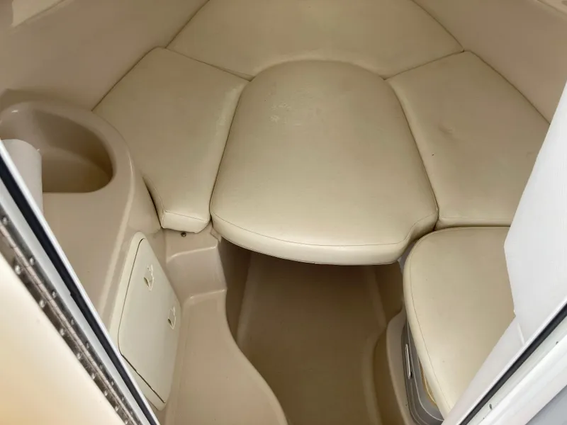 Slide: The Image of 2014 Wellcraft 232 Coastal cabin interior with beige seating and storage compartments. - 10