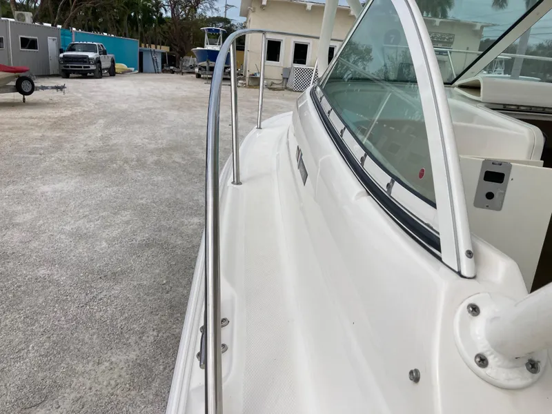 Slide: The Image of 2014 Wellcraft 232 Coastal boat docked, showcasing sleek design and windshield. - 11