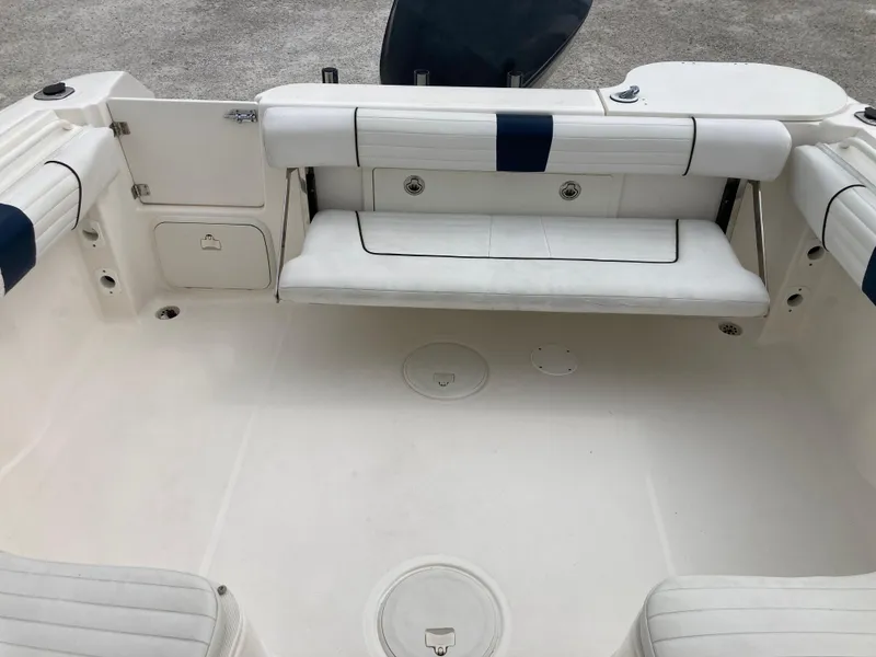 Slide: The Image of 2014 Wellcraft 232 Coastal boat interior with white seating and storage compartments. - 19