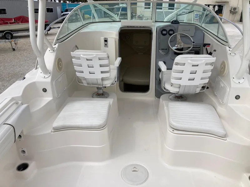 Slide: The Image of 2014 Wellcraft 232 Coastal boat interior with dual white seats and steering console. - 6