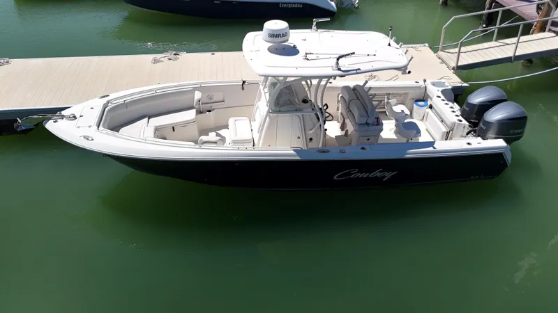 The Image of 2015 Sailfish 290cc boat docked, featuring dual engines and spacious seating. - 1