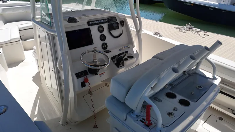 Slide: The Image of 2015 Sailfish 290cc boat cockpit with steering wheel, control panel, and seating. - 10