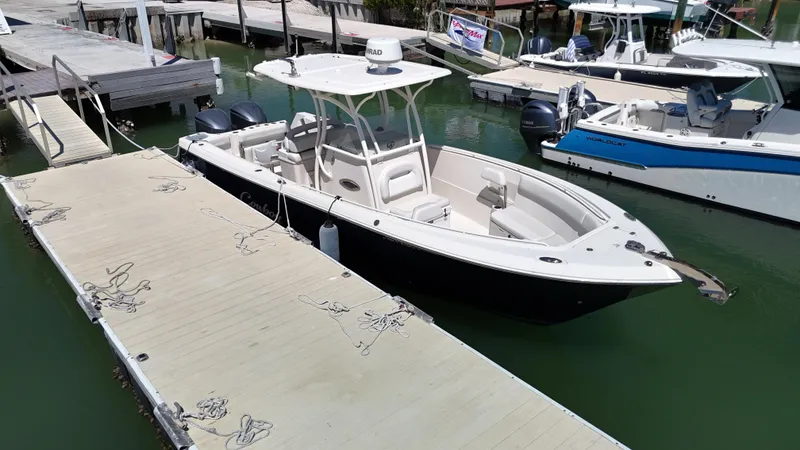 Slide: The Image of 2015 Sailfish 290cc boat docked at a marina, featuring sleek design and spacious seating. - 4