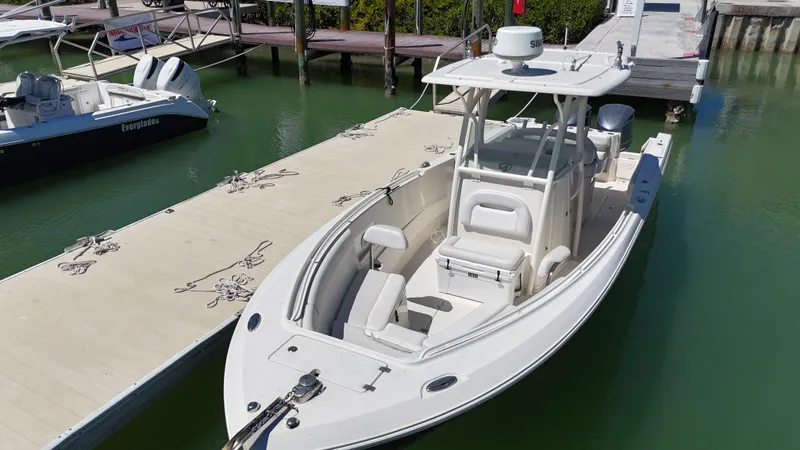 Slide: The Image of 2015 Sailfish 290cc boat docked in marina, featuring sleek design and spacious seating. - 6