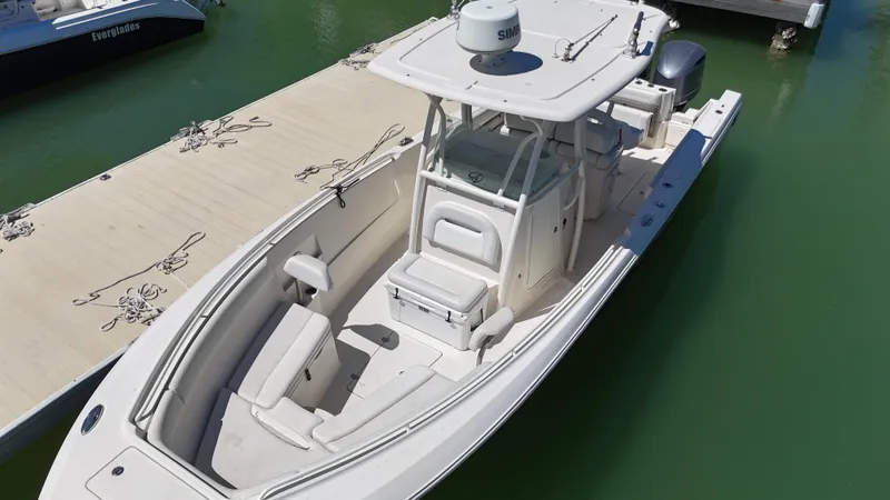 Slide: The Image of 2015 Sailfish 290cc boat docked on calm green water. - 7