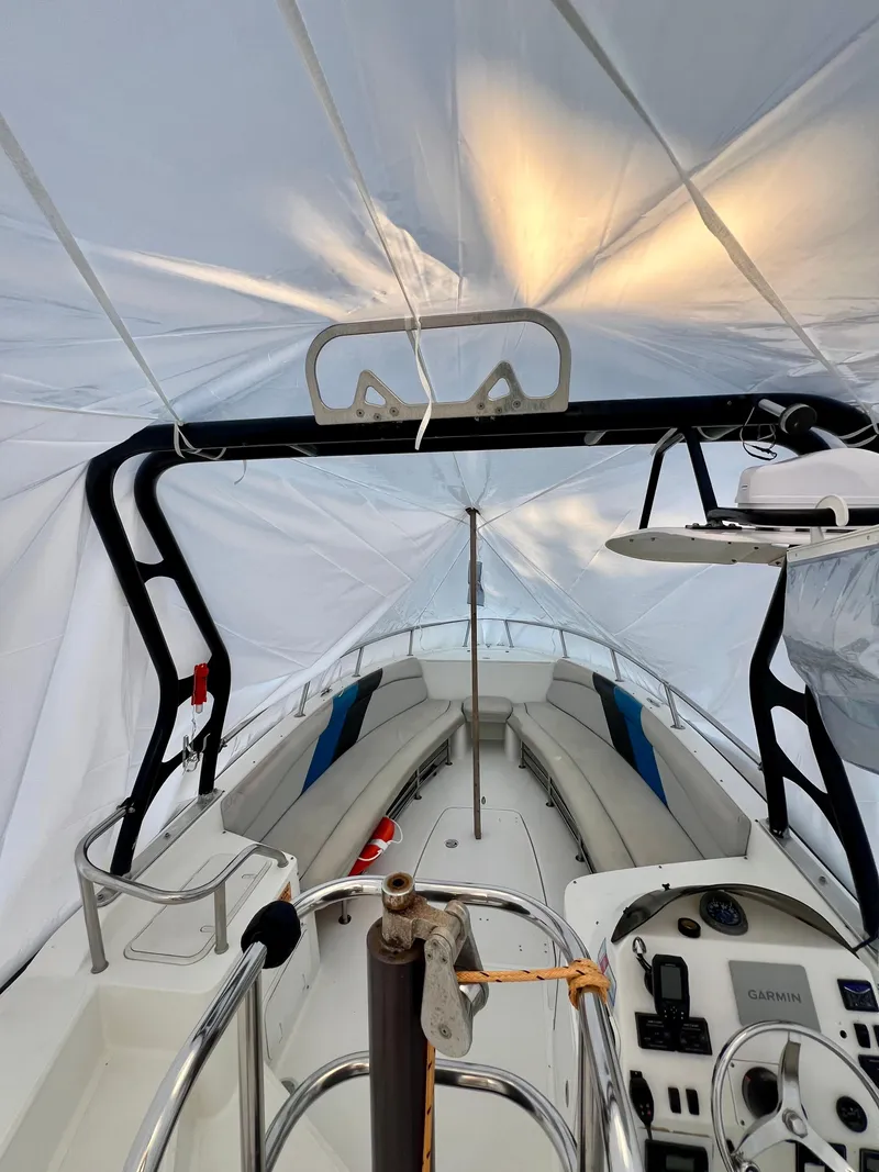 Slide: The Image of 2010 Centurion Parasail Boat interior under tarp, showcasing controls and seating. - 11