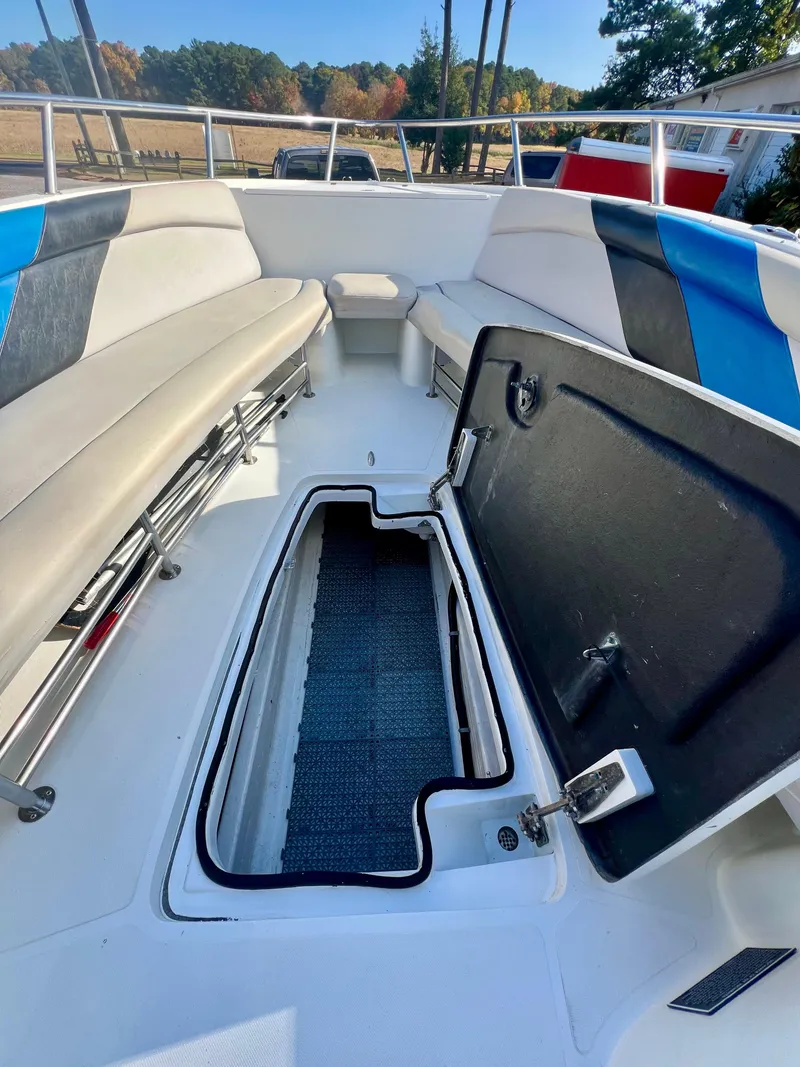 Slide: The Image of 2010 Centurion Parasail Boat interior with open storage compartment, featuring cushioned seating and vibrant accents. - 8