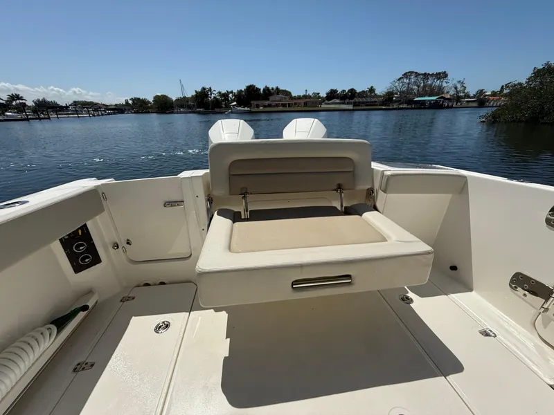 Slide: The Image of 2023 Boston Whaler 280 Vantage boat interior with seating, overlooking calm waters. - 11