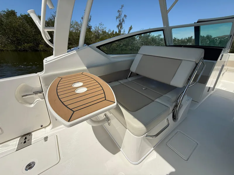 Slide: The Image of 2023 Boston Whaler 280 Vantage interior with seating and foldable table, showcasing luxury design. - 14