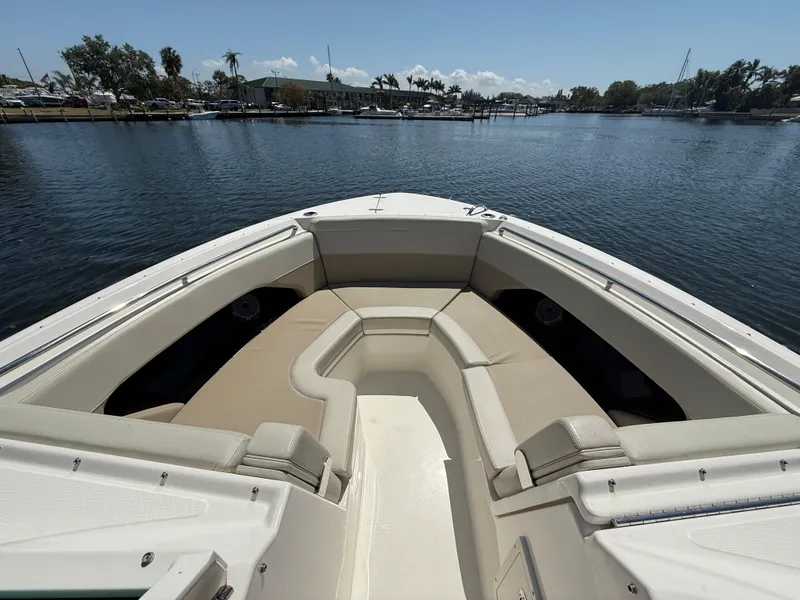 Slide: The Image of 2023 Boston Whaler 280 Vantage boat with spacious seating, docked on a serene waterfront. - 25