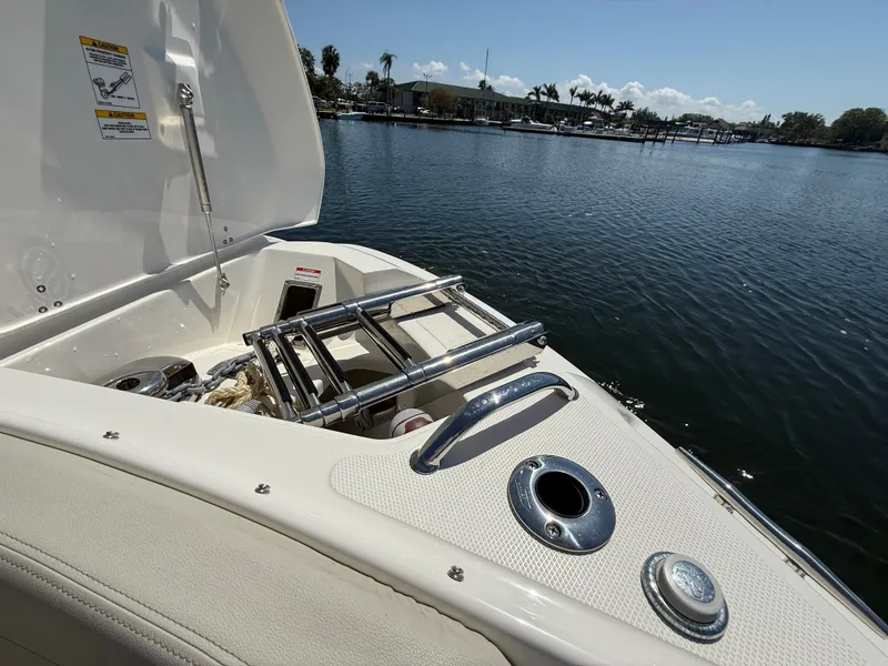 Slide: The Image of 2023 Boston Whaler 280 Vantage boat with open storage compartment by the water. - 27