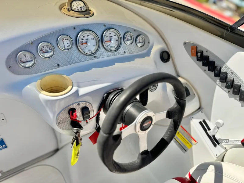 Slide: The Image of 2002 Baja 24H2X boat dashboard with steering wheel and gauges. - 24