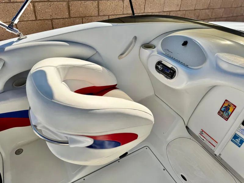 Slide: The Image of 2002 Baja 24H2X boat interior with white and red seating, dashboard, and controls. - 14