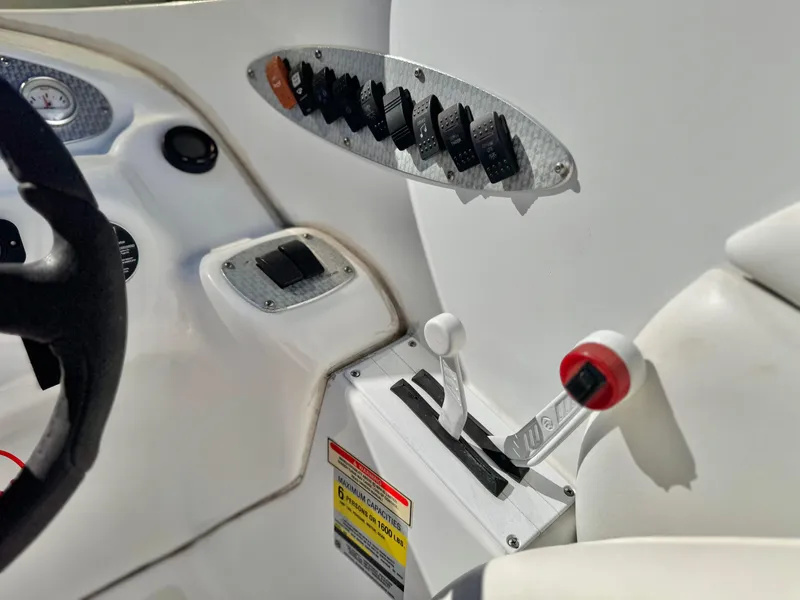 Slide: The Image of Control panel of a 2002 Baja 24H2X boat with steering wheel and switches. - 26
