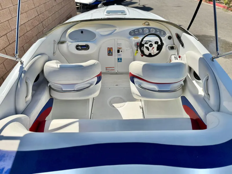 Slide: The Image of 2002 Baja 24H2X boat interior with white seats and dashboard controls. - 8
