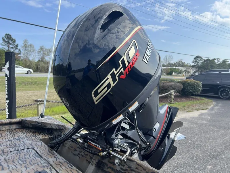 Slide: The Image of 2025 Xpress XP18CC boat with Yamaha SHO VMAX outboard motor, parked outdoors. - 10