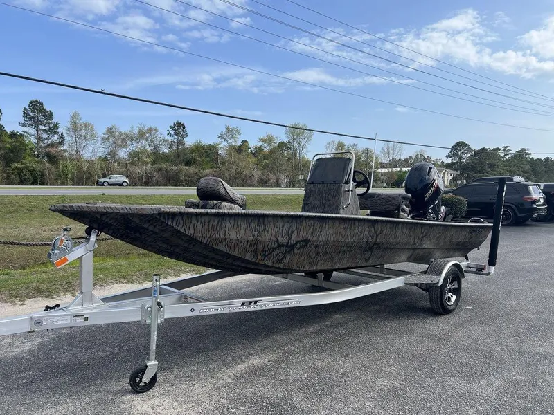 Slide: The Image of 2025 Xpress XP18CC boat on trailer, parked outdoors under a clear sky. - 2