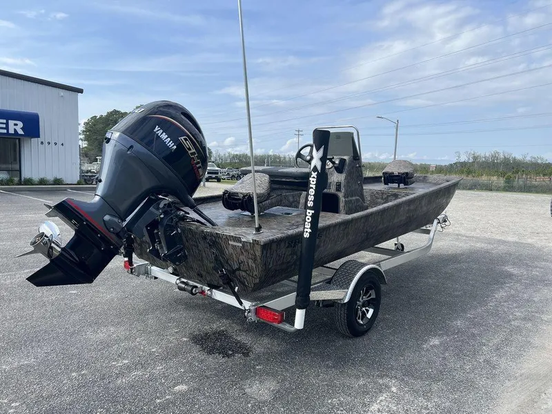 Slide: The Image of 2025 Xpress XP18CC boat on trailer with Yamaha outboard motor, parked outdoors. - 6