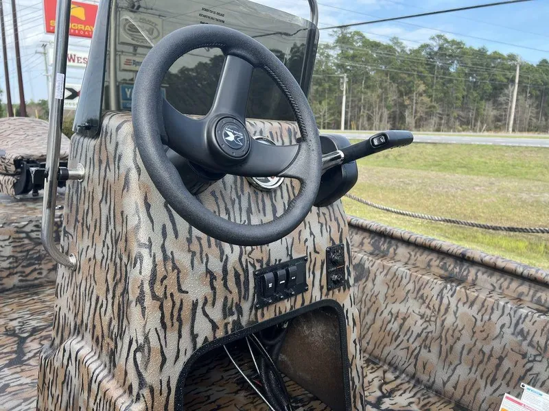 Slide: The Image of 2025 Xpress XP18CC boat console with camouflage design and steering wheel. - 9