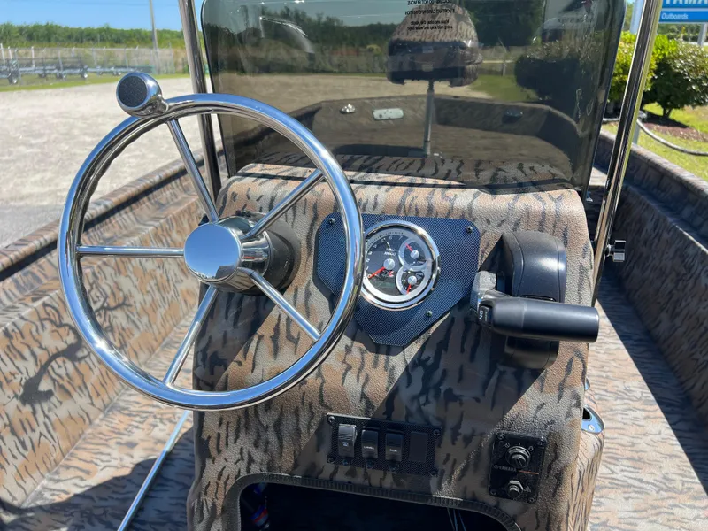 Slide: The Image of 2025 Xpress XP20CC boat dashboard with camo design and chrome steering wheel. - 12