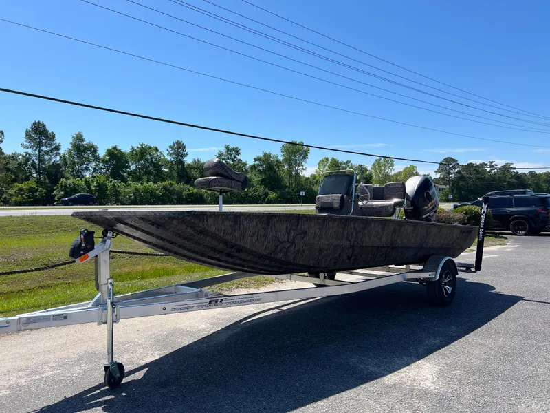 Slide: The Image of 2025 Xpress XP20CC boat on trailer, parked outdoors under clear blue sky. - 2
