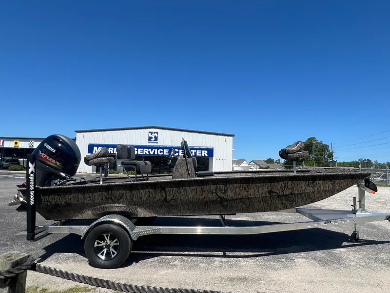 Slide: The Image of 2025 Xpress XP20CC boat on trailer, parked outside service center under clear blue sky. - 4