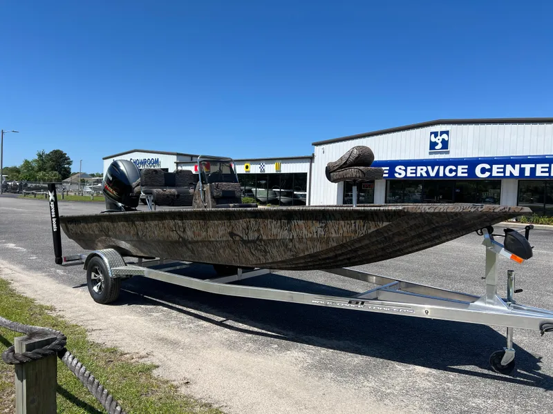 Slide: The Image of 2025 Xpress XP20CC boat on trailer outside service center, clear sky background. - 5