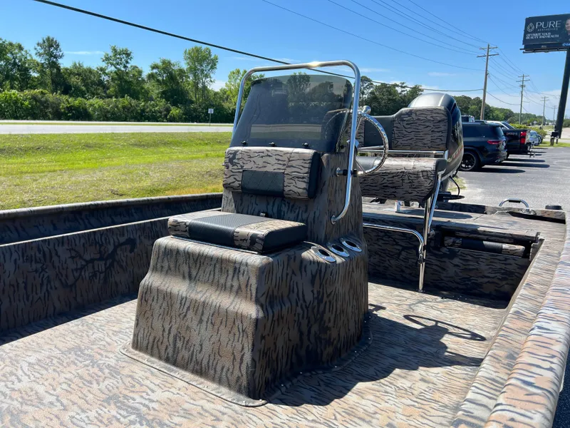 Slide: The Image of 2025 Xpress XP20CC boat with camouflage design, parked outdoors on a sunny day. - 9