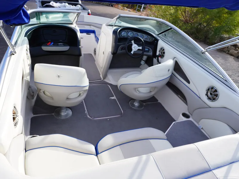 Slide: The Image of 2013 Bryant 220 boat interior with white seating and modern dashboard. - 11