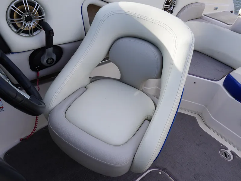 Slide: The Image of Captain's seat in a 2013 Bryant 220 boat, featuring white upholstery and modern design. - 16