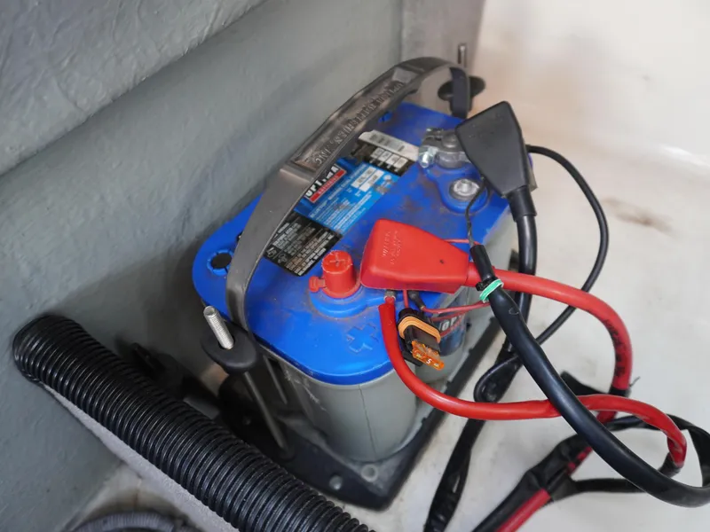 Slide: The Image of Battery with red and black cables in a 2013 Bryant 220 boat. - 18