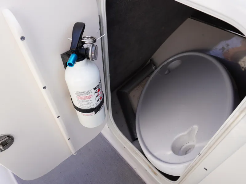 Slide: The Image of Fire extinguisher and toilet in a 2013 Bryant 220 boat compartment. - 22