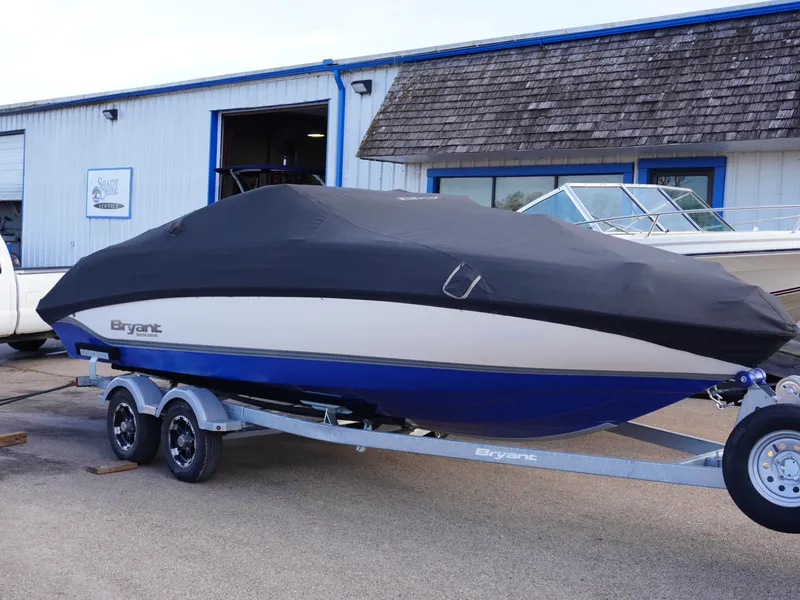 Slide: The Image of Covered 2013 Bryant 220 boat on trailer outside a building. - 25